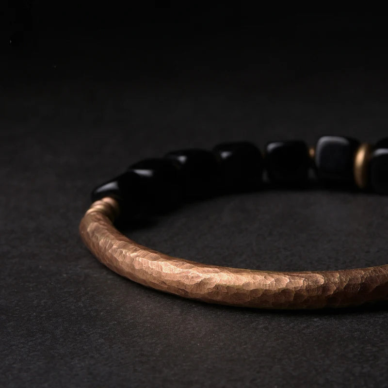 Bracelet da obsidian ner da fatg a man.