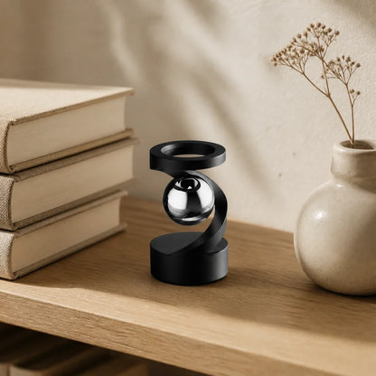 Black levitation spinner styled on an oak bookshelf beside books and a ceramic vase